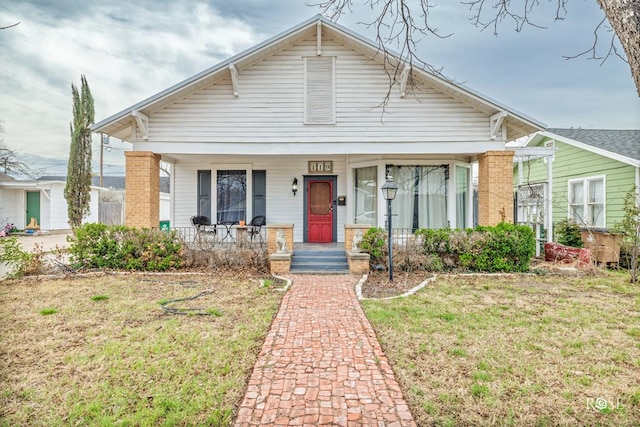 bungalow-style home with covered porch and a front lawn