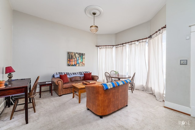 carpeted living room with a chandelier