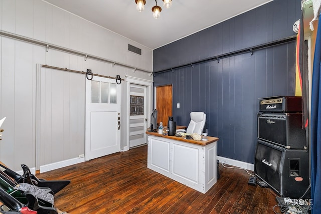 home office with dark wood-type flooring and wooden walls