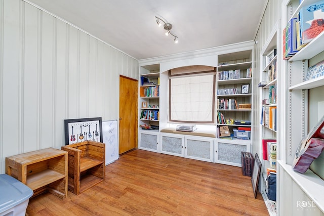 sitting room featuring crown molding and light hardwood / wood-style flooring