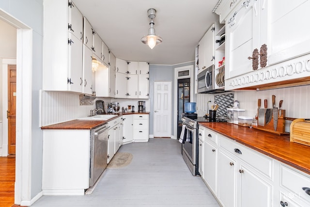 kitchen with appliances with stainless steel finishes, sink, and white cabinets