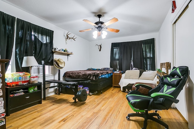 bedroom with a closet, ceiling fan, and light hardwood / wood-style flooring