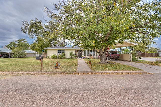 view of front of home with a carport and a front lawn