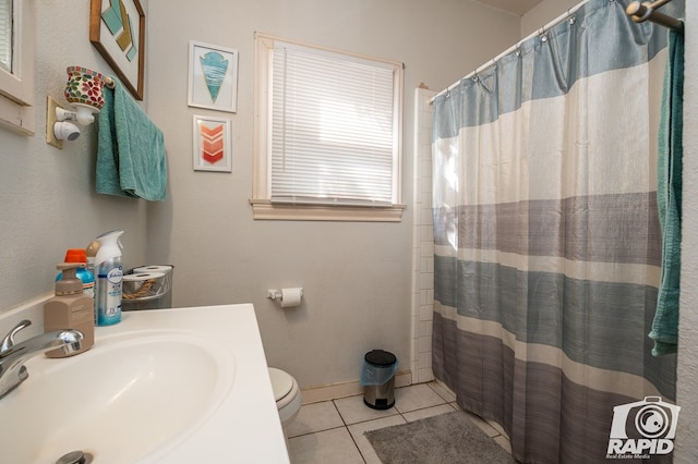 bathroom with walk in shower, tile patterned floors, toilet, and sink