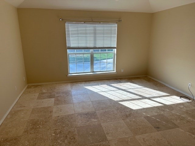 unfurnished room with lofted ceiling