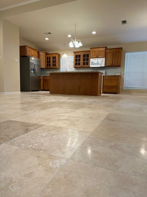 kitchen featuring stainless steel refrigerator with ice dispenser, kitchen peninsula, hanging light fixtures, and a notable chandelier