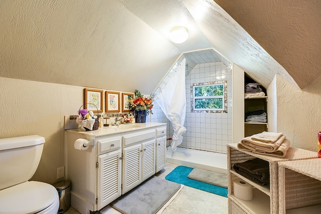 bathroom featuring lofted ceiling, sink, toilet, a textured ceiling, and a shower with shower curtain