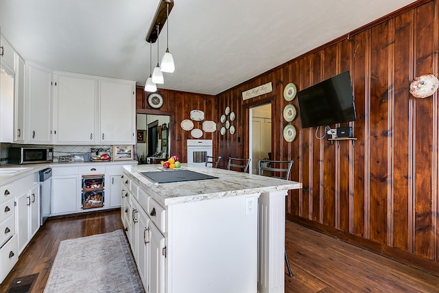 kitchen featuring stainless steel appliances, white cabinetry, a kitchen island, and dark hardwood / wood-style floors