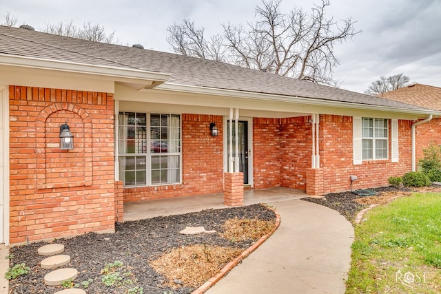3102 Chatterton Dr, San Angelo, TX 76904 - doorway to property with covered porch, brick siding, and a shingled roof