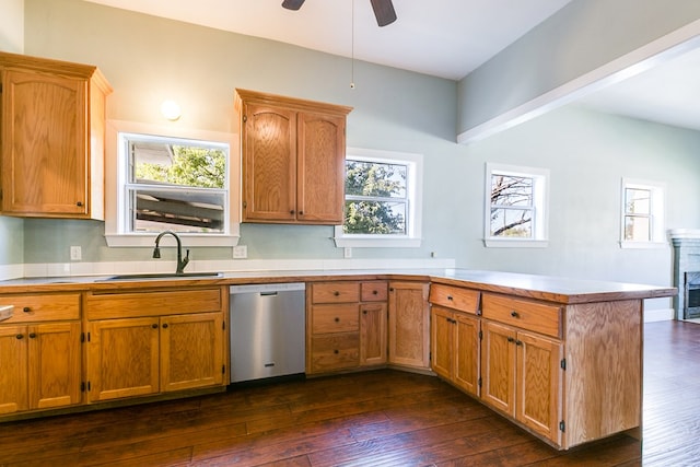 kitchen featuring dishwasher, sink, dark hardwood / wood-style flooring, kitchen peninsula, and plenty of natural light