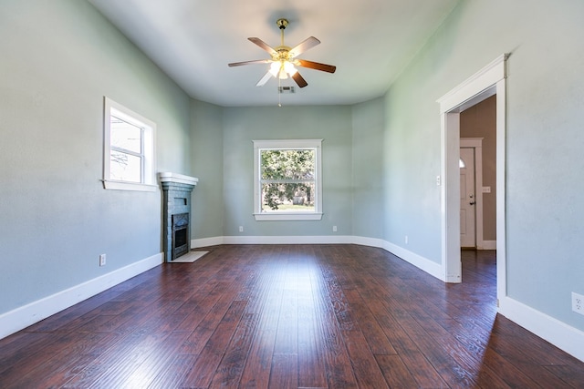 unfurnished living room with ceiling fan, a healthy amount of sunlight, and dark hardwood / wood-style floors