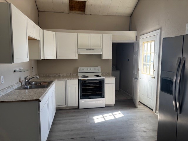 445 8th St, San Angelo, TX 76901 - kitchen with white electric stove, stainless steel fridge with ice dispenser, under cabinet range hood, a sink, and light wood-style flooring