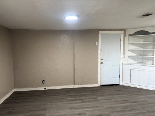 445 8th St, San Angelo, TX 76901 - spare room featuring wood finished floors and baseboards