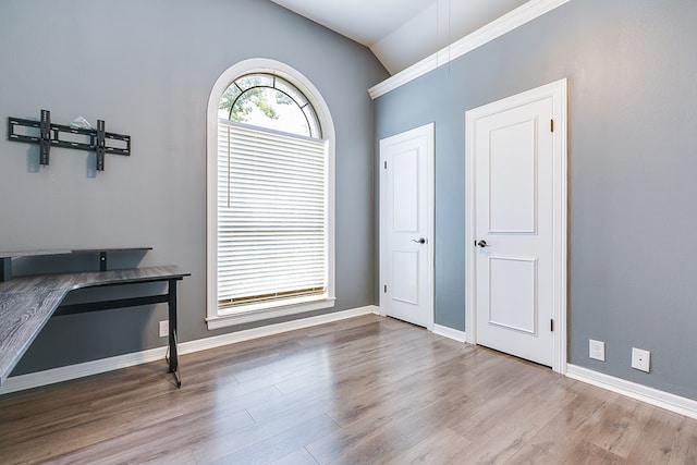 1001 Avondale Ave, San Angelo, TX 76901 - unfurnished dining area with vaulted ceiling, wood finished floors, and baseboards