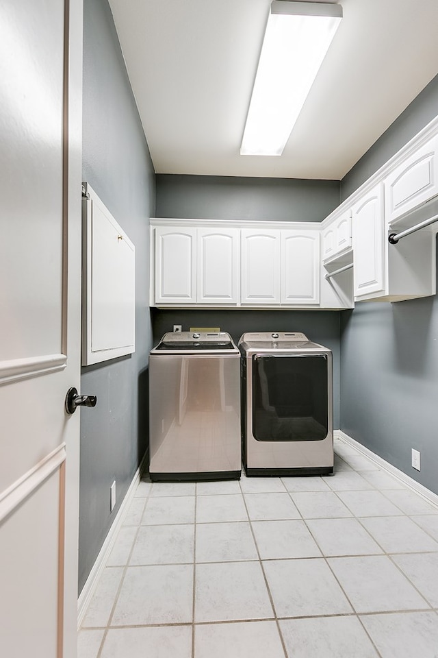1001 Avondale Ave, San Angelo, TX 76901 - laundry room featuring washing machine and dryer, cabinet space, baseboards, and light tile patterned flooring