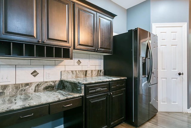1001 Avondale Ave, San Angelo, TX 76901 - kitchen featuring stainless steel refrigerator with ice dispenser, backsplash, light stone counters, light wood-style floors, and dark brown cabinetry