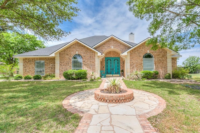 1001 Avondale Ave, San Angelo, TX 76901 - view of front facade with brick siding, a front yard, and a chimney