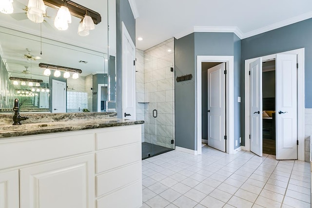 1001 Avondale Ave, San Angelo, TX 76901 - bathroom featuring vanity, a stall shower, tile patterned floors, baseboards, and ornamental molding