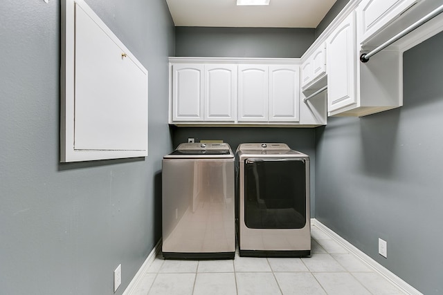 1001 Avondale Ave, San Angelo, TX 76901 - laundry room with cabinet space, washer and clothes dryer, light tile patterned floors, and baseboards