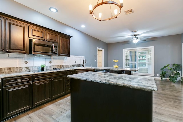 1001 Avondale Ave, San Angelo, TX 76901 - kitchen featuring stainless steel microwave, black electric stovetop, a sink, light wood-style flooring, and recessed lighting
