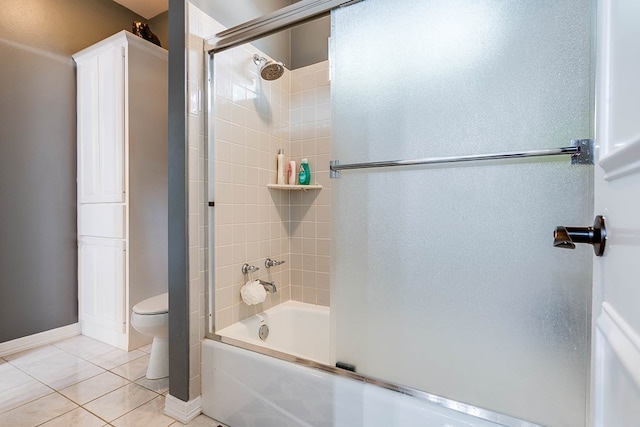1001 Avondale Ave, San Angelo, TX 76901 - bathroom with toilet, enclosed tub / shower combo, tile patterned floors, and baseboards