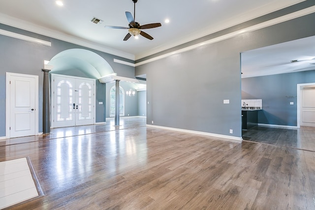 1001 Avondale Ave, San Angelo, TX 76901 - spare room with arched walkways, ceiling fan, crown molding, ornate columns, and wood finished floors