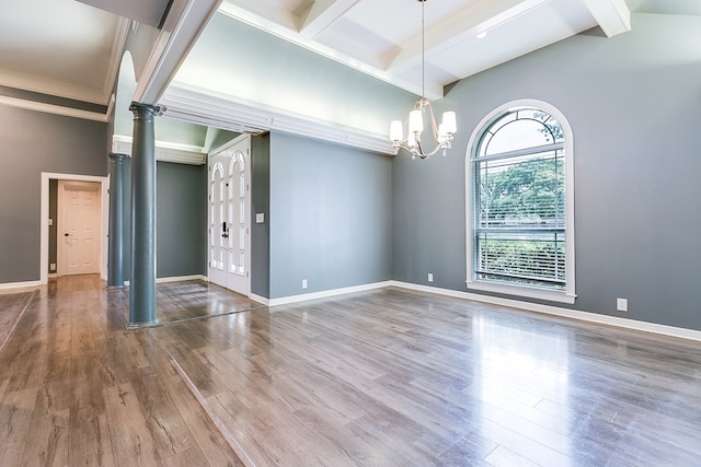 1001 Avondale Ave, San Angelo, TX 76901 - unfurnished room featuring decorative columns, beam ceiling, wood finished floors, a chandelier, and baseboards