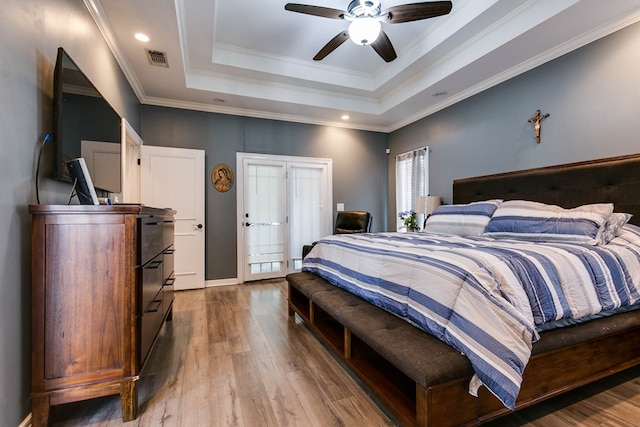 1001 Avondale Ave, San Angelo, TX 76901 - bedroom with a tray ceiling, wood finished floors, recessed lighting, ceiling fan, and crown molding