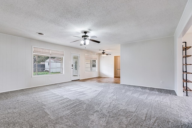 spare room with ceiling fan, light carpet, and a textured ceiling