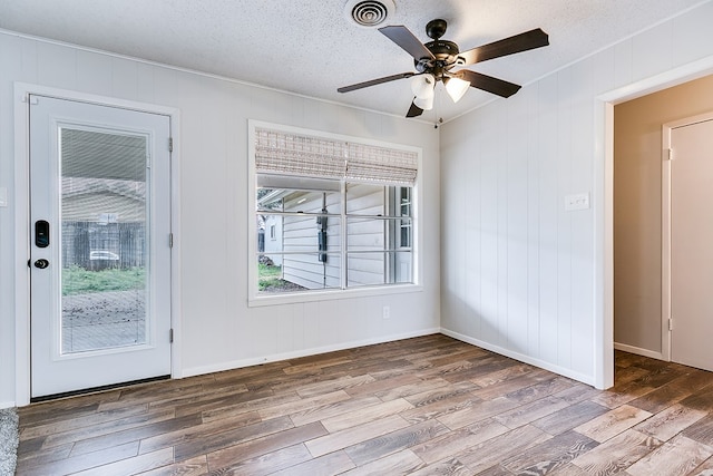 empty room featuring hardwood / wood-style flooring, ceiling fan, and a textured ceiling