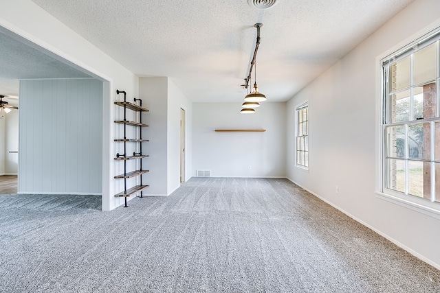 carpeted empty room featuring a textured ceiling and ceiling fan