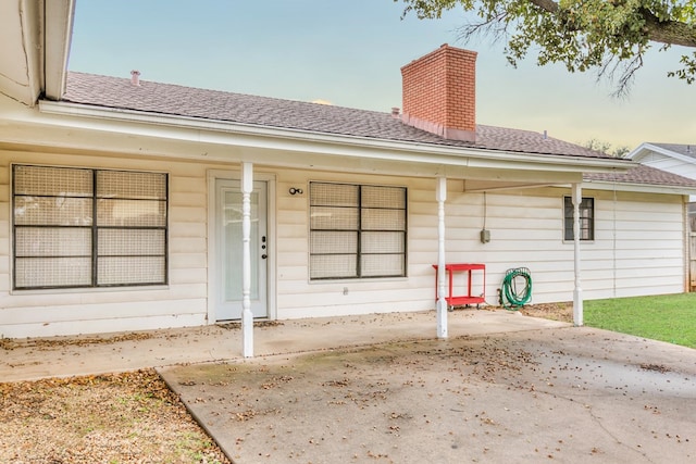 exterior entry at dusk featuring covered porch