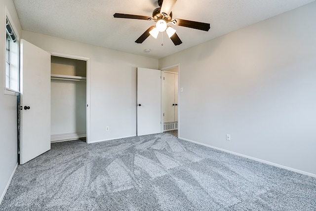 unfurnished bedroom with ceiling fan, carpet floors, a textured ceiling, and a closet