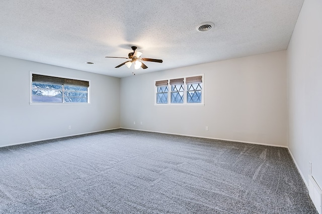 carpeted empty room with ceiling fan and a textured ceiling