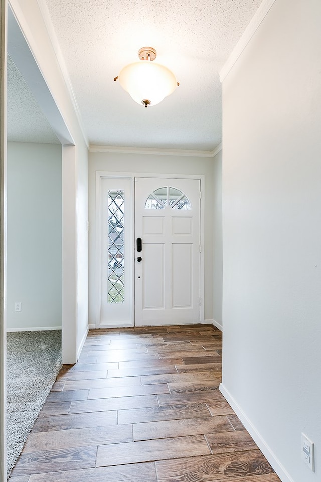 foyer featuring a textured ceiling, ornamental molding, and hardwood / wood-style flooring