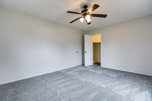 unfurnished bedroom with a textured ceiling, a closet, carpet floors, and ceiling fan