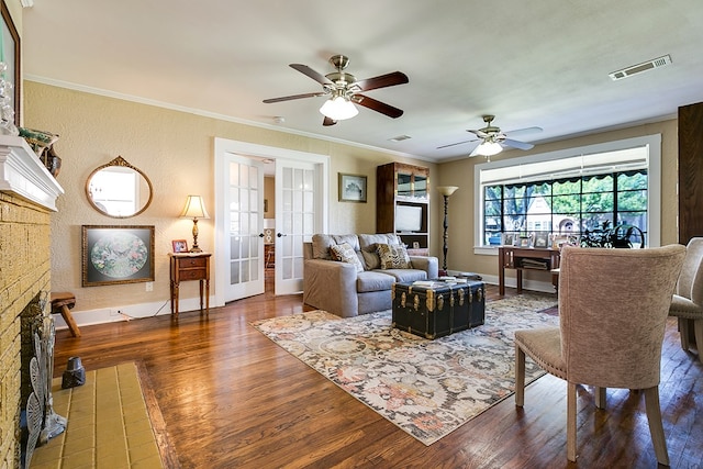 living room with dark wood-type flooring, ornamental molding, and french doors