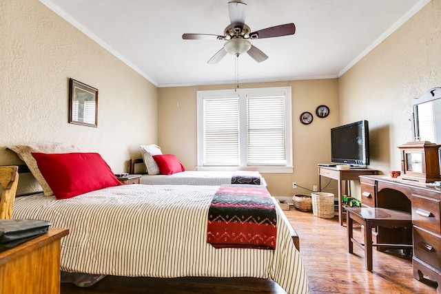 bedroom with crown molding, ceiling fan, and light wood-type flooring