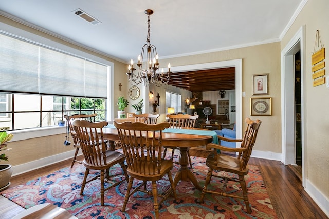 dining area featuring crown molding, a chandelier, and dark hardwood / wood-style flooring