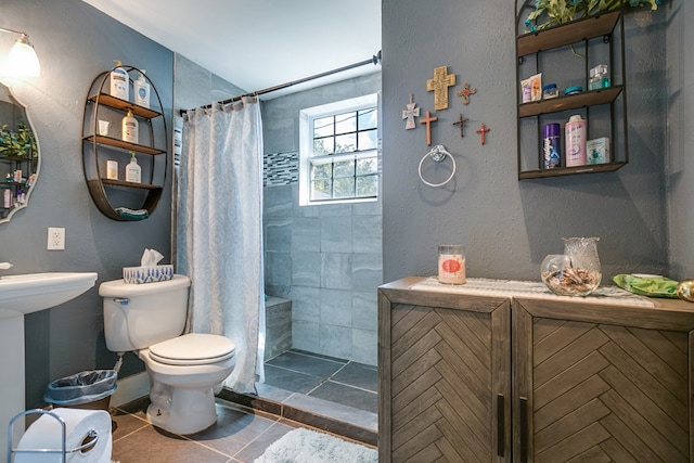 bathroom with sink, curtained shower, tile patterned floors, and toilet