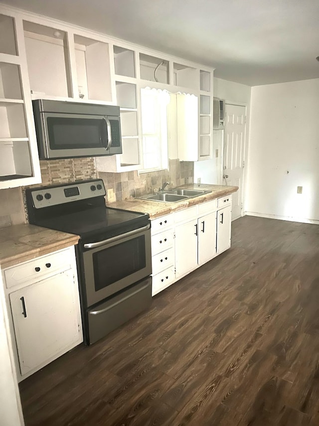 kitchen with dark wood-type flooring, sink, white cabinetry, stainless steel appliances, and decorative backsplash