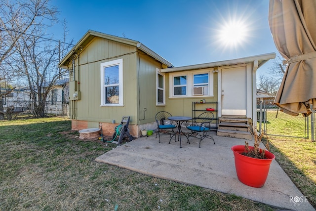 back of property featuring entry steps, a patio, a lawn, and fence