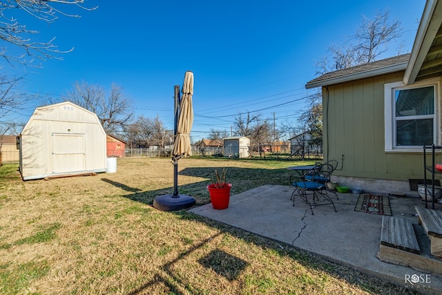 view of yard with fence private yard, a patio, an outbuilding, and a shed