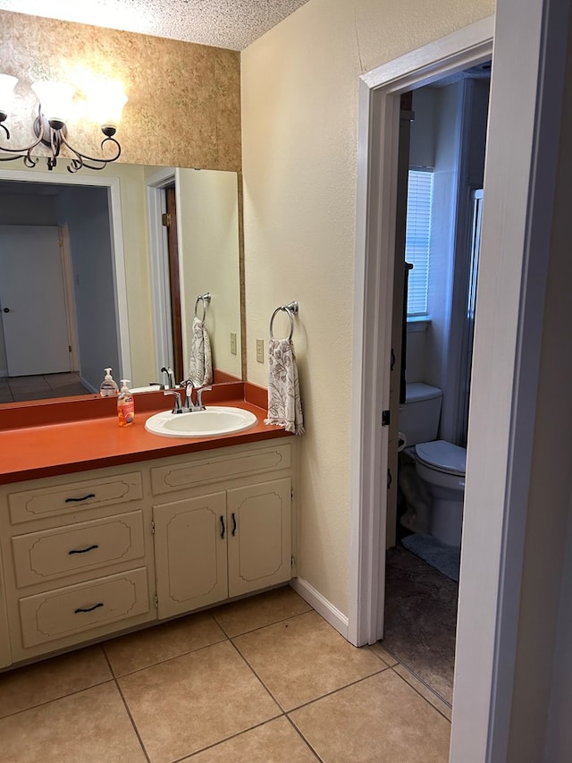 bathroom featuring tile patterned flooring, vanity, a textured ceiling, and toilet