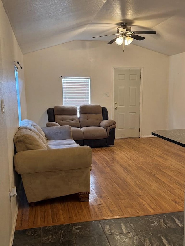 living room featuring lofted ceiling, hardwood / wood-style floors, a textured ceiling, and ceiling fan