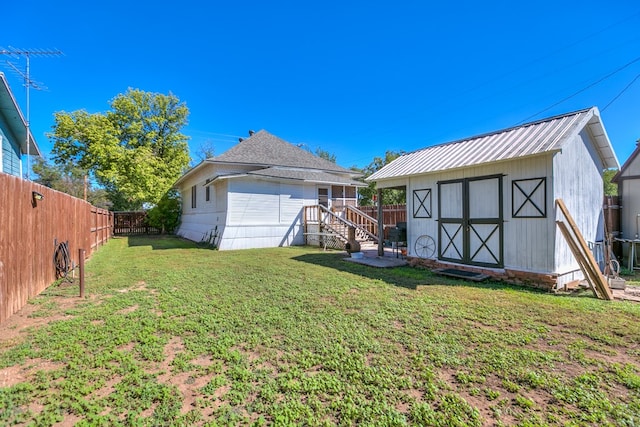 rear view of house with a shed and a yard