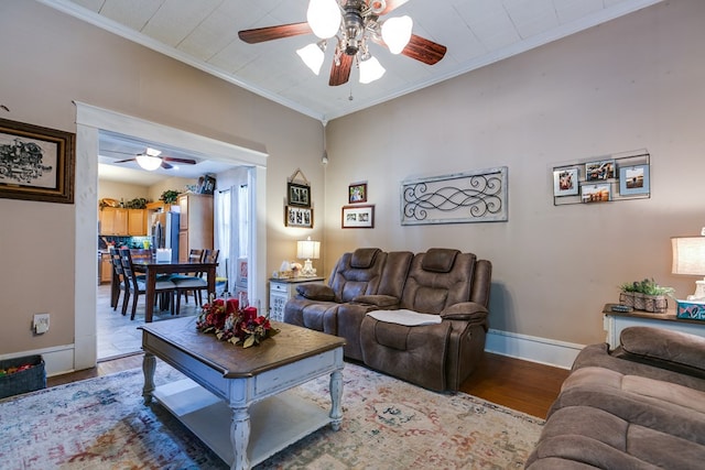 living room with crown molding, ceiling fan, and light wood-type flooring