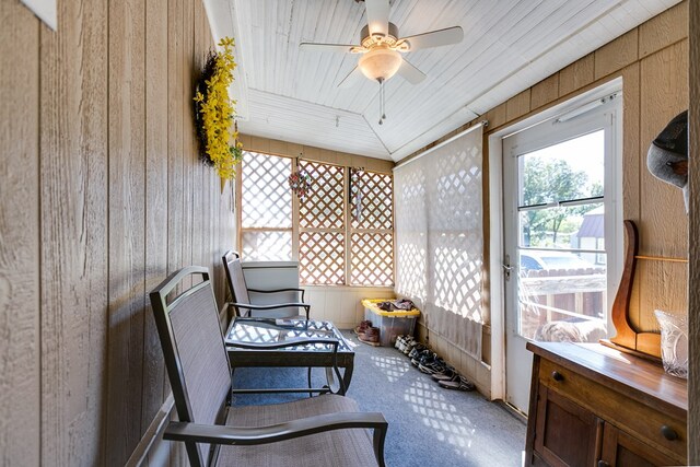 sunroom / solarium with vaulted ceiling, wooden ceiling, and ceiling fan