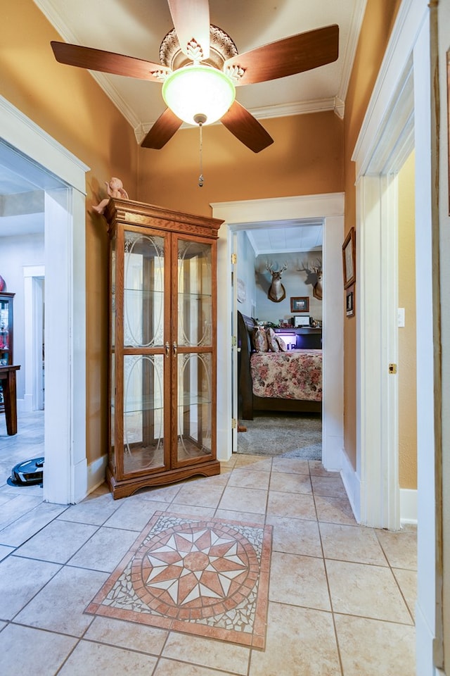 hallway with ornamental molding and light tile patterned flooring