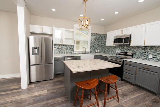 kitchen featuring gray cabinets, white cabinetry, appliances with stainless steel finishes, and a kitchen island